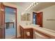 Bright bathroom featuring double sinks, a large mirror with vanity lighting, and wood-trimmed doorways at 2713 W Long Dr # C, Littleton, CO 80120