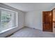 A carpeted bedroom with a window view to trees outside, and a doorway to a hallway at 2713 W Long Dr # C, Littleton, CO 80120