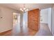 Open-concept dining room featuring hardwood floors, chandelier, and unique brick column accent at 2713 W Long Dr # C, Littleton, CO 80120