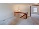 Upstairs hallway with carpet, a wooden railing, and a light fixture at 2713 W Long Dr # C, Littleton, CO 80120