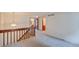 Upstairs hallway with carpet, a wooden railing, and doors to the bedrooms and bathrooms at 2713 W Long Dr # C, Littleton, CO 80120