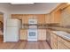 Kitchen boasting light wood cabinets, white appliances, and durable countertops at 2713 W Long Dr # C, Littleton, CO 80120
