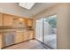 Charming kitchen featuring tile backsplash, wood cabinets, and access to the backyard patio at 2713 W Long Dr # C, Littleton, CO 80120