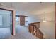 Carpeted loft area with wooden banisters and a brick feature, creating a cozy upper-level retreat at 2713 W Long Dr # C, Littleton, CO 80120