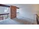 Open carpeted loft with brick accent and wooden rails, providing a bright, versatile space at 2713 W Long Dr # C, Littleton, CO 80120