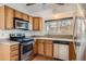 Kitchen features oak cabinets, stainless steel appliances, and hardwood floors at 1011 Thames St, Highlands Ranch, CO 80126