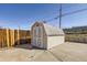 Exterior view of the shed in the backyard with double doors and concrete pad at 3016 S Grape Way, Denver, CO 80222
