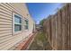 Narrow grass and brick path between the house and fence at 3016 S Grape Way, Denver, CO 80222