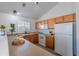 Efficient kitchen includes light countertops, white appliances, light wood cabinets, and a bright sunny window at 3260 E 103Rd Pl # 912, Thornton, CO 80229