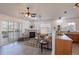Bright living room features a fireplace, ceiling fan, sliding glass door to balcony, and sleek gray laminate flooring at 3260 E 103Rd Pl # 912, Thornton, CO 80229