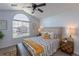 Bright main bedroom features a ceiling fan, large sunny arched window, neutral colors, and sleek laminate flooring at 3260 E 103Rd Pl # 912, Thornton, CO 80229