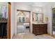 Ensuite bathroom with a dark wood vanity, decorative mirror, and tiled walk-in shower at 848 S Emerson St, Denver, CO 80209