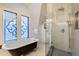 Bathroom featuring a clawfoot tub, decorative windows, and tiled shower at 848 S Emerson St, Denver, CO 80209