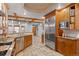 Gourmet kitchen boasts stainless steel appliances, wood cabinets, and stone tile floors at 848 S Emerson St, Denver, CO 80209