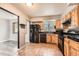 Traditional kitchen with wood cabinets, black appliances, tile flooring, and a window over the sink at 16623 E Asbury Pl, Aurora, CO 80013