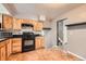 Functional kitchen featuring wooden cabinets, black appliances, and tile floors at 16623 E Asbury Pl, Aurora, CO 80013
