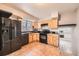 Efficient kitchen featuring wood cabinets, black appliances, and tile flooring at 16623 E Asbury Pl, Aurora, CO 80013
