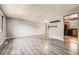 Spacious living room featuring sleek flooring, neutral walls, and an open doorway to the kitchen at 16623 E Asbury Pl, Aurora, CO 80013