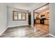 Open-concept space with wood-look floors, a bay window, and a view into the kitchen at 16623 E Asbury Pl, Aurora, CO 80013