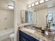 Bathroom with granite countertops, blue cabinetry, neutral walls, and a large mirror, offering a spa-like atmosphere at 1020 15Th St # 24H, Denver, CO 80202
