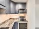 View of the kitchen featuring modern stainless steel appliances, navy cabinets and stylish marble countertops at 1020 15Th St # 24H, Denver, CO 80202