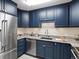 Modern kitchen equipped with stainless steel appliances, navy cabinets, and elegant marble countertops, perfect for cooking at 1020 15Th St # 24H, Denver, CO 80202