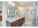 Bathroom features a double vanity, large mirror, and walk-in shower with glass doors and tile accents at 8460 E 54Th Dr, Denver, CO 80238