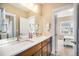 Well-lit bathroom with dual sinks, a large mirror, and modern fixtures, adjoining the main bedroom at 8460 E 54Th Dr, Denver, CO 80238