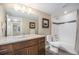 Modern bathroom with granite counters, dark wood cabinets, and a shower-tub combo for added convenience at 8460 E 54Th Dr, Denver, CO 80238