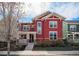 Charming red two-story home with a welcoming front porch and well-maintained landscaping at 8460 E 54Th Dr, Denver, CO 80238