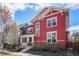 Beautiful two story red home with well-maintained landscaping and a covered porch at 8460 E 54Th Dr, Denver, CO 80238