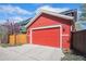 Spacious two-car garage with a red door and adjacent driveway, providing ample parking and storage space at 8460 E 54Th Dr, Denver, CO 80238