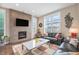 Cozy living room featuring a modern fireplace, large windows, and comfortable seating at 8460 E 54Th Dr, Denver, CO 80238