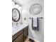Chic bathroom with wood cabinets, white countertops and a stylish circular mirror at 1239 S Flower Cir # C, Lakewood, CO 80232