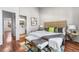 Cozy main bedroom with adjacent bathroom featuring a bench, artwork and hardwood flooring at 1239 S Flower Cir # C, Lakewood, CO 80232