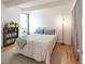 Bedroom with wood floors and a queen bed. Includes bookshelf and window at 777 N Washington St # 508, Denver, CO 80203