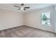 Spacious bedroom featuring neutral walls, a ceiling fan, plush carpet, and a bright window at 450 Lone Pine St, Fort Lupton, CO 80621