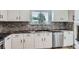 Modern kitchen boasting white cabinets, stainless steel appliances, stylish backsplash, and sleek countertops at 450 Lone Pine St, Fort Lupton, CO 80621