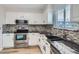 Modern kitchen boasting white cabinets, stainless steel appliances, stylish backsplash, and sleek countertops at 450 Lone Pine St, Fort Lupton, CO 80621