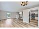 Living room with light hardwood floors open to the kitchen and a staircase leading to the second floor at 450 Lone Pine St, Fort Lupton, CO 80621