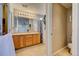 This bathroom features double sinks, wood cabinets, a large mirror and tile floors at 10061 Apollo Bay Way, Highlands Ranch, CO 80130
