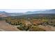 Breathtaking aerial view of a wooded landscape with rolling hills and distant mountain peaks on a bright, sunny day at 4473 Echo Dr, Larkspur, CO 80118