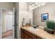 Well-lit bathroom with a sink, plants, and a view of an open doorway at 4473 Echo Dr, Larkspur, CO 80118