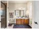 Well-lit bathroom with dual sinks, wood cabinets, and a glass-enclosed shower at 4473 Echo Dr, Larkspur, CO 80118