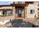 Inviting front entrance featuring stone accents, a covered porch, and manicured landscaping at 4473 Echo Dr, Larkspur, CO 80118