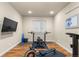 Home gym features a flat screen television, workout equipment and wood-style floors at 4473 Echo Dr, Larkspur, CO 80118