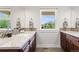 Bathroom with dual sinks, granite countertop, modern fixtures, and a bright window at 4589 Quandary Peak St, Brighton, CO 80601