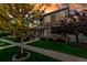 Landscaped front yard with trees and green grass leading to a well-maintained home with a covered porch and stone accents at 4589 Quandary Peak St, Brighton, CO 80601
