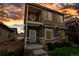Charming two-story home featuring stone accents, a cozy front porch, and welcoming curb appeal set against a vibrant sky at 4589 Quandary Peak St, Brighton, CO 80601