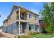 Charming two-story home with a cozy front porch and well-manicured lawn on a sunny day at 4589 Quandary Peak St, Brighton, CO 80601